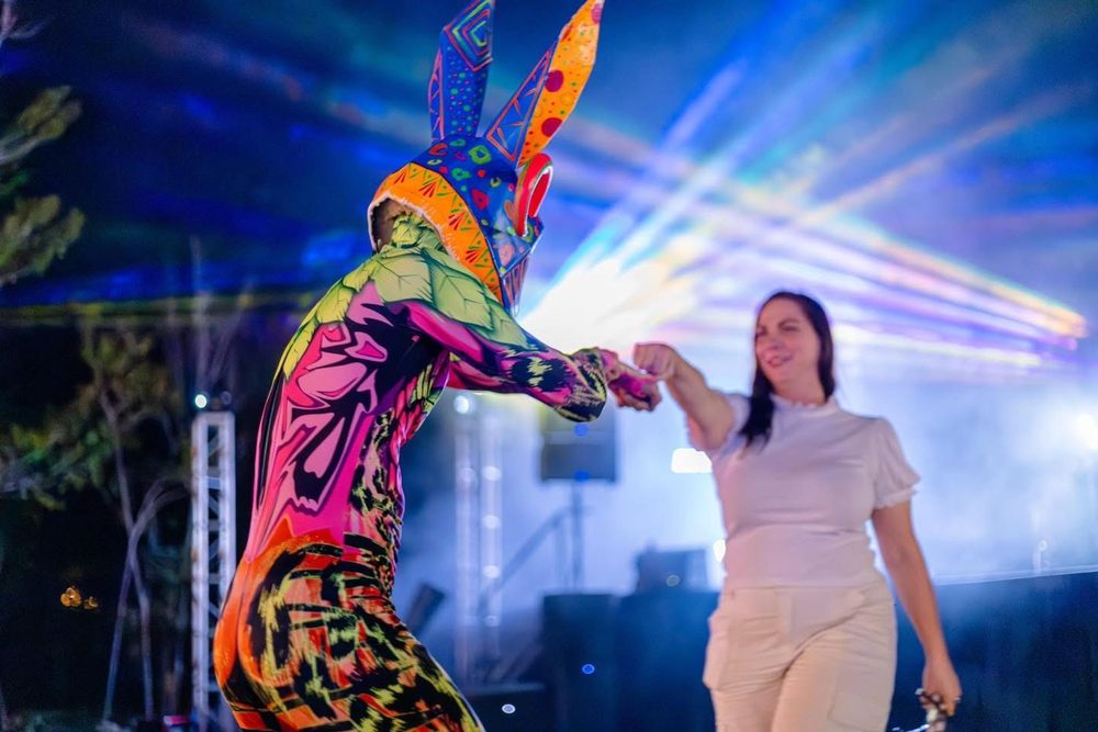 An alebrije performer dancing with a guest on stage